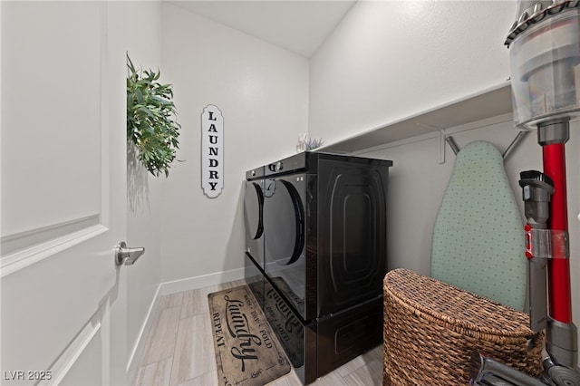 laundry area featuring washing machine and dryer and light hardwood / wood-style floors