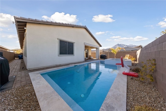 view of pool with an in ground hot tub and a patio