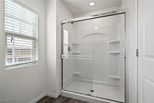 bathroom with wood-type flooring and a shower with door