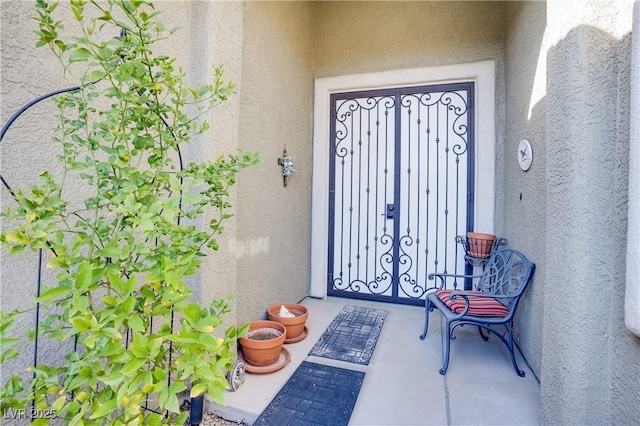 doorway to property featuring stucco siding