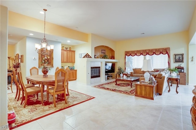 living room featuring recessed lighting, a notable chandelier, and a tile fireplace