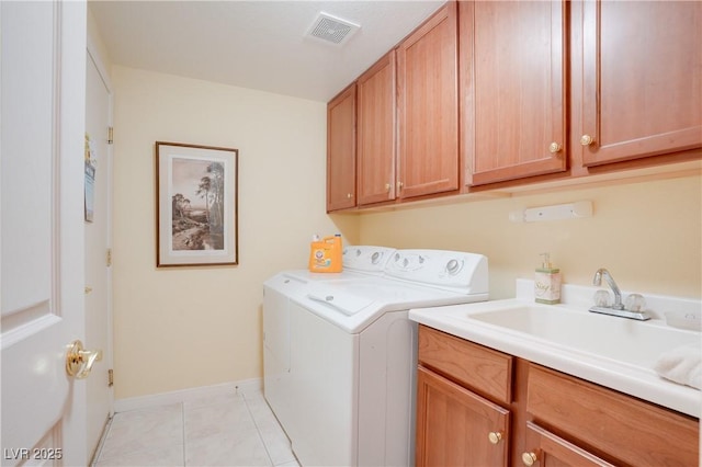 clothes washing area with light tile patterned floors, cabinet space, visible vents, a sink, and independent washer and dryer