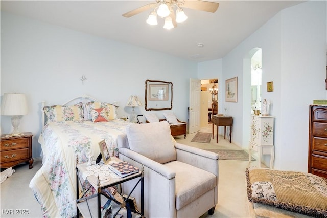 bedroom featuring arched walkways, ceiling fan, and light colored carpet