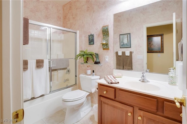 full bathroom featuring tile patterned floors, vanity, toilet, and bath / shower combo with glass door