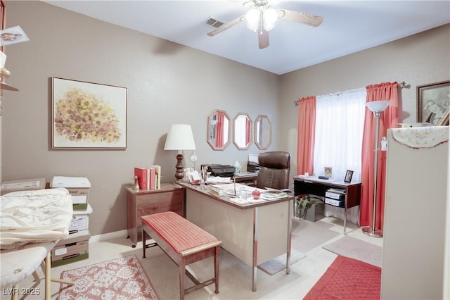 office with visible vents, light colored carpet, a ceiling fan, and baseboards