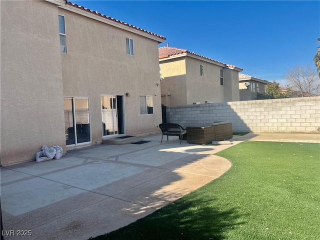 back of house with outdoor lounge area, a patio area, and a lawn