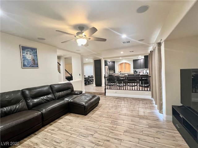 living room featuring ceiling fan and light wood-type flooring