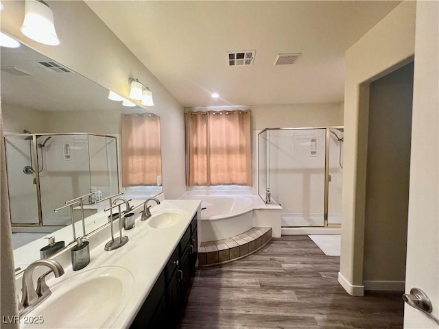 bathroom featuring vanity, separate shower and tub, and hardwood / wood-style floors