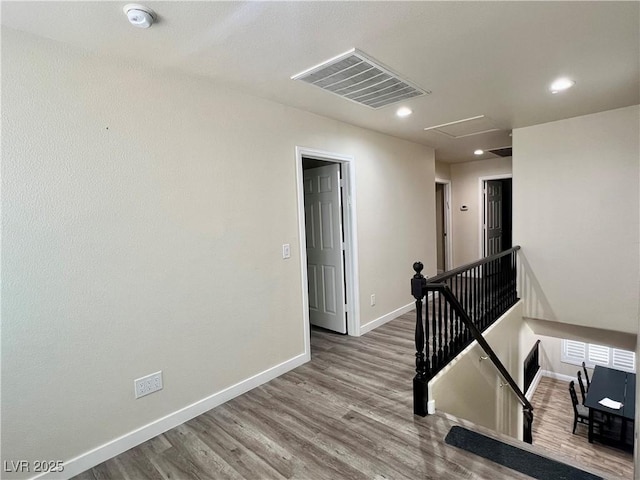 10618 Timber Stand St, Las Vegas, NV 89183 - hallway with baseboards, an upstairs landing, visible vents, and wood finished floors