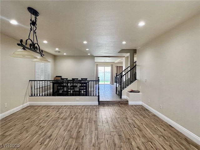 10618 Timber Stand St, Las Vegas, NV 89183 - unfurnished living room featuring stairway, wood finished floors, baseboards, and recessed lighting