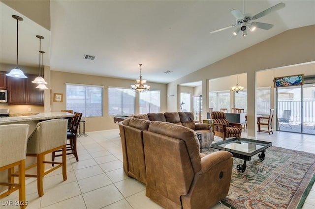 tiled living room with vaulted ceiling and ceiling fan with notable chandelier