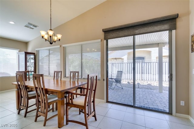 dining room with an inviting chandelier, lofted ceiling, and light tile patterned floors