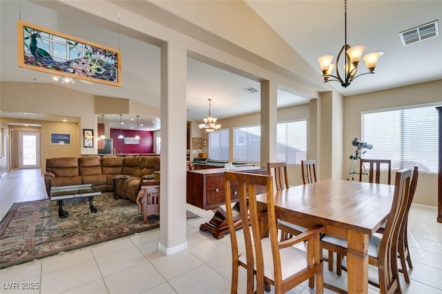 dining area featuring lofted ceiling, light tile patterned floors, and a chandelier