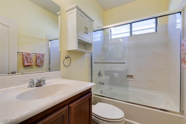 full bathroom with vanity, shower / bath combination with glass door, and toilet