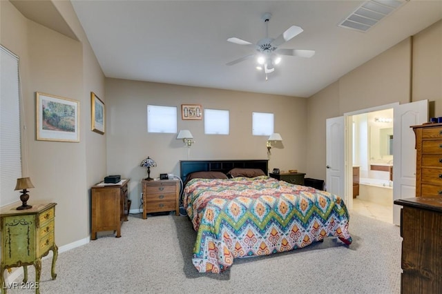 bedroom with ceiling fan, lofted ceiling, connected bathroom, and light carpet