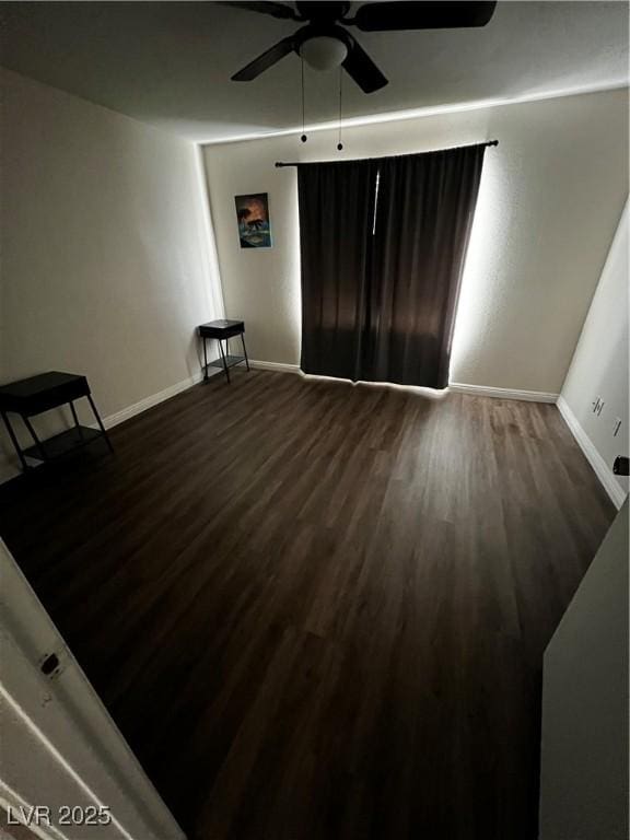 spare room with dark wood-type flooring and ceiling fan