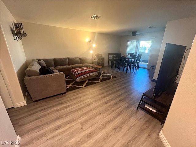 living room featuring hardwood / wood-style flooring and ceiling fan