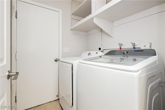 laundry area featuring washing machine and dryer and light tile patterned floors