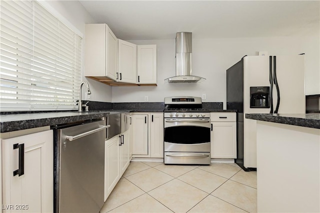 kitchen with stainless steel appliances, white cabinetry, wall chimney range hood, and light tile patterned floors