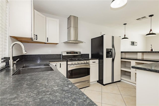 kitchen with sink, refrigerator with ice dispenser, stainless steel gas range, extractor fan, and white cabinets