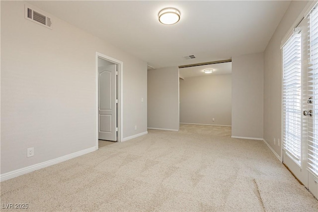 unfurnished room featuring plenty of natural light and light colored carpet