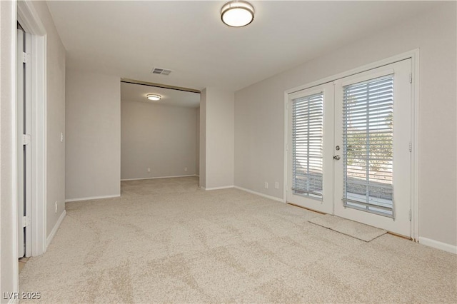 carpeted spare room with french doors