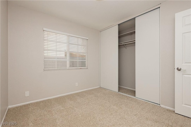 unfurnished bedroom featuring a closet and light carpet