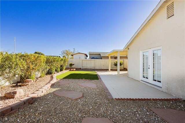 view of yard featuring a patio and french doors