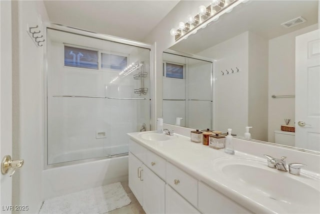 full bathroom with vanity, enclosed tub / shower combo, and toilet