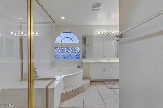 bathroom with vanity, a tub, and tile patterned floors