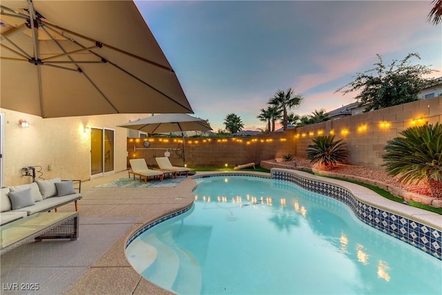 pool at dusk featuring a patio