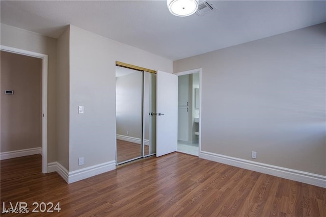 unfurnished bedroom featuring dark hardwood / wood-style floors and a closet