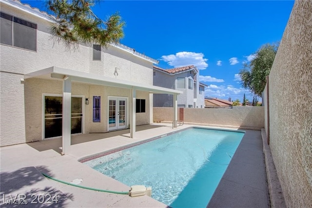 view of swimming pool featuring a patio and french doors