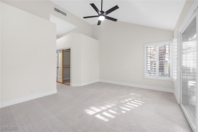 carpeted spare room with ceiling fan and high vaulted ceiling