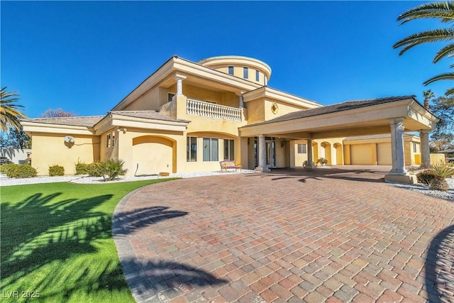 exterior space with a yard, a garage, and a balcony