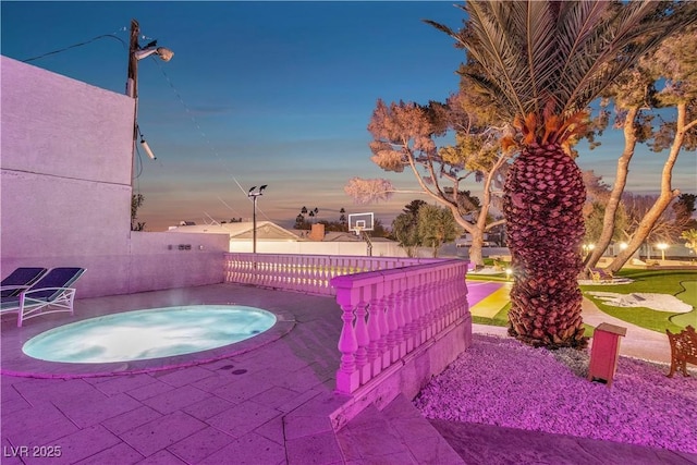 patio terrace at dusk featuring an in ground hot tub