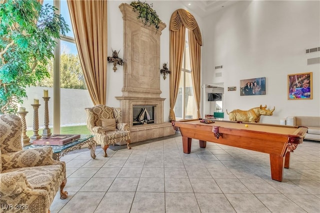 playroom featuring a towering ceiling, pool table, and light tile patterned floors