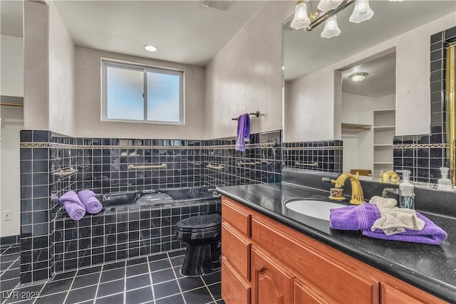 bathroom featuring vanity, toilet, tile patterned flooring, and tiled tub