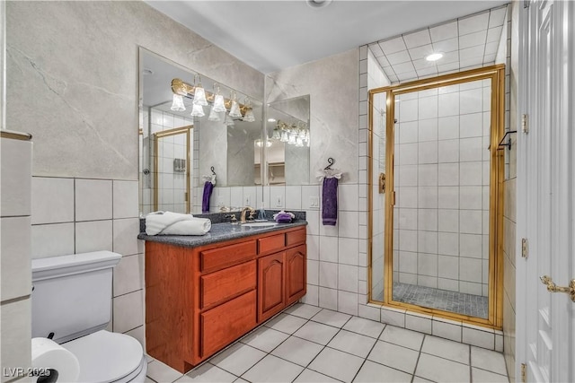 bathroom with tile patterned floors, vanity, an enclosed shower, and tile walls