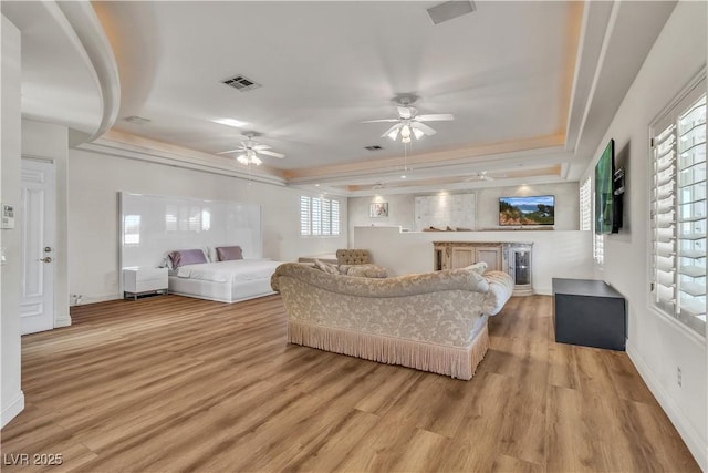 bedroom featuring a raised ceiling and light hardwood / wood-style floors