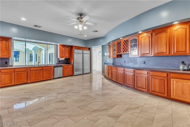 kitchen featuring sink, decorative backsplash, ceiling fan, and appliances with stainless steel finishes