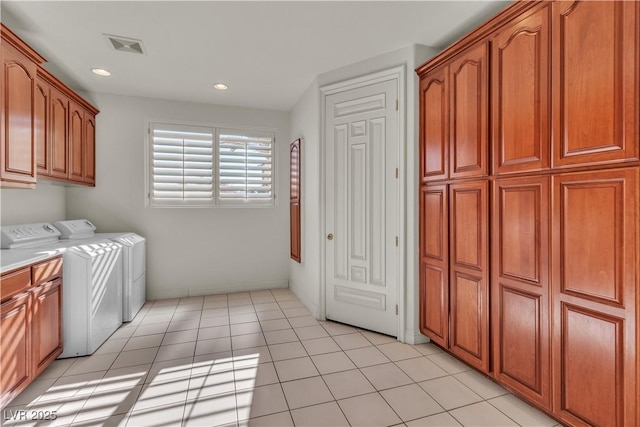 laundry room with cabinets, light tile patterned flooring, and washer and clothes dryer