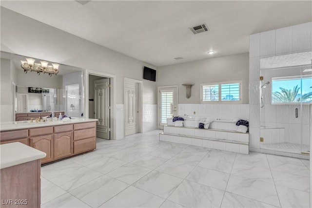 bathroom featuring independent shower and bath, vanity, and a chandelier