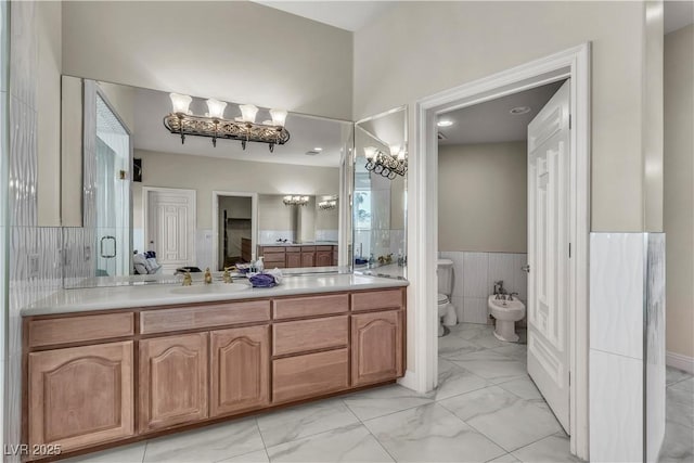 bathroom with a bidet, vanity, and toilet