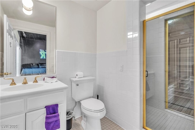 bathroom with tile walls, vanity, tile patterned flooring, and a shower with door