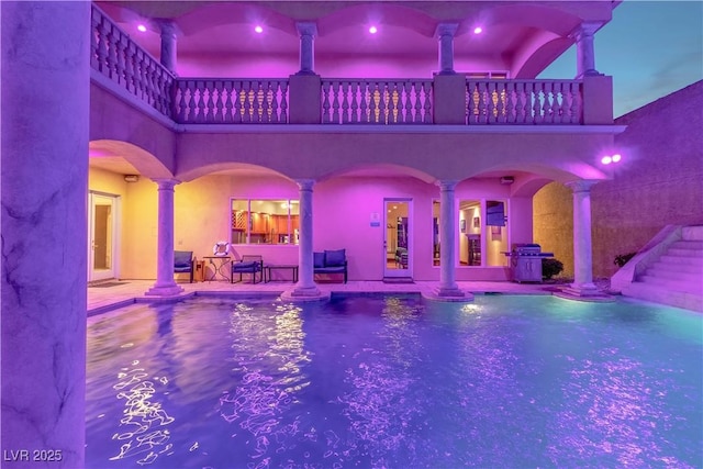 view of pool featuring ornate columns and a grill