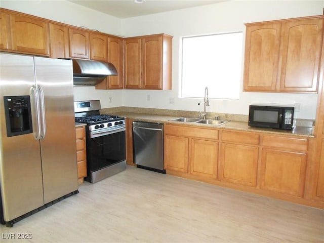 kitchen featuring stainless steel appliances, sink, and light hardwood / wood-style floors