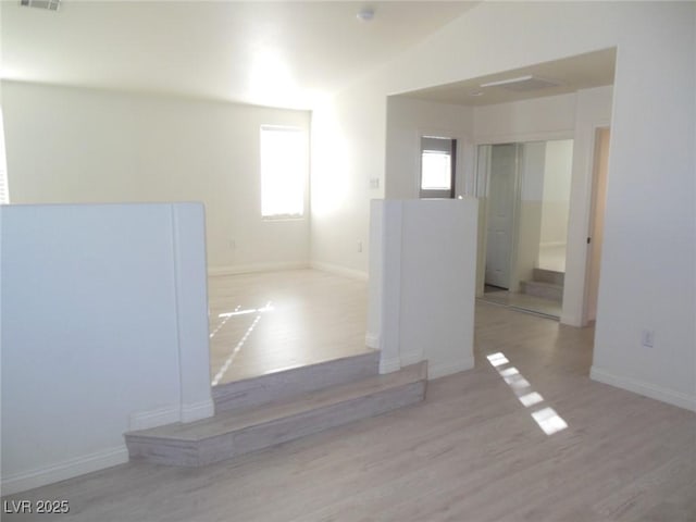 bathroom featuring wood-type flooring, vaulted ceiling, and a wealth of natural light