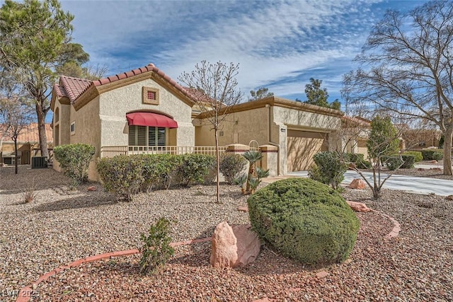 mediterranean / spanish house with a garage and central AC unit