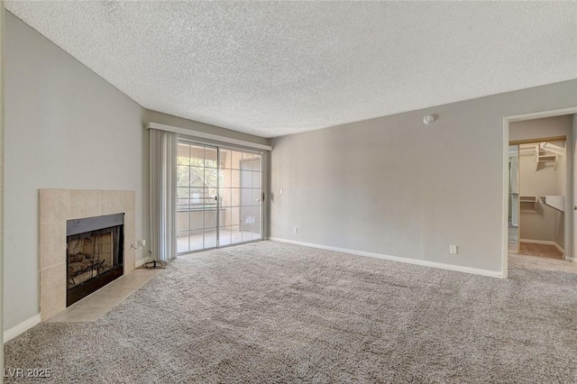 unfurnished living room with light carpet, a fireplace, and a textured ceiling